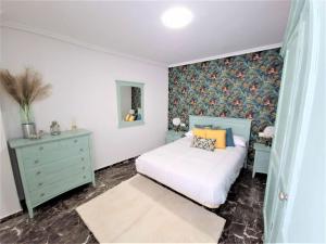 a bedroom with a white bed and a dresser and a bed sidx sidx sidx at Piso-Loft COS Centro Jaén 2 in Jaén