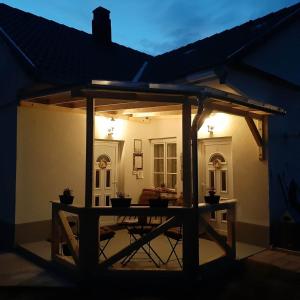 een patio met een tafel in het midden van een huis bij Edina Vintage Vendégház in Mosonmagyaróvár