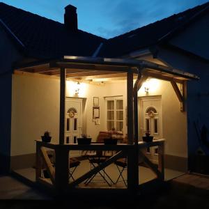 un patio con una mesa en el medio de una casa en Edina Vintage Vendégház, en Mosonmagyaróvár