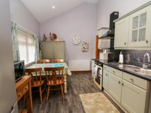 cocina con mesa, sillas y fregadero en Willow Lodge, en Brough