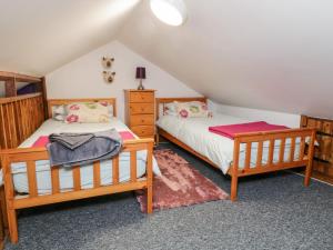 2 camas individuais num quarto com um sótão em Willow Lodge em Brough
