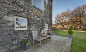 a stone house with two chairs and a table at Cedar Nook in Loweswater