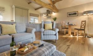 a living room with a couch and a chair and a table at Cedar Nook in Loweswater