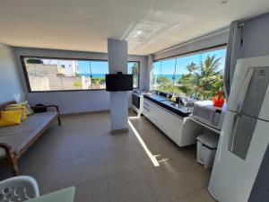 a kitchen with a view of the ocean from a room at Apt FRENTE MAR MEAIPE COMPLETO in Guarapari