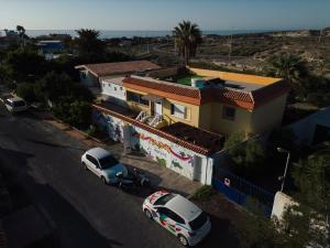 una macchina bianca parcheggiata di fronte a una casa di Hostel Los Amigos Yoga & Wellness a La Mareta