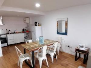 Excelente apartamento en Montevideo في مونتيفيديو: مطبخ وغرفة طعام مع طاولة وكراسي خشبية
