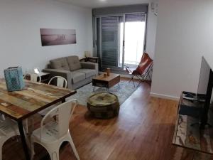 un soggiorno con divano, tavolo e sedie di Excelente apartamento en Montevideo a Montevideo