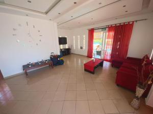 una gran sala de estar con un reloj grande en la pared en VILLA L'OR with Private Pool en Flic-en-Flac