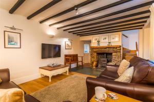 sala de estar con sofá y chimenea en Dove Holme Cottage, en Grasmere