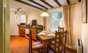 a kitchen with a wooden table and a dining room at Dove Holme Cottage in Grasmere