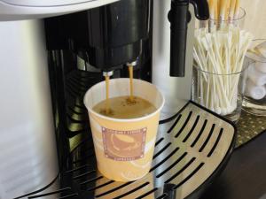 a coffee maker is making a cup of coffee at Hotel Sunroute Hikone in Hikone