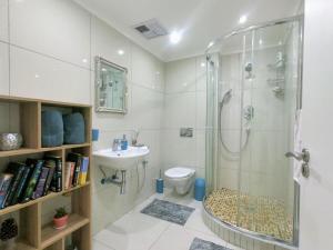 a bathroom with a shower and a toilet and a sink at Stunning 2 Bed - Rooftop Braai Area - Sunset Views in Durban