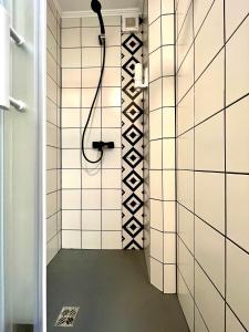 y baño con ducha y paredes de azulejos blancos. en Grandeur, en Timisoara
