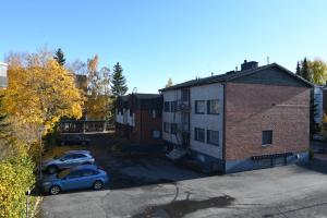 an apartment building with a car parked in a parking lot at Matkustajakoti Evakko asunnot in Seinäjoki