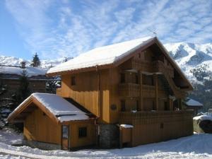 a large wooden building with snow on the roof at Appartement Méribel, 1 pièce, 3 personnes - FR-1-180-35 in Méribel