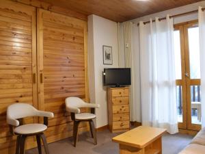 ein Wohnzimmer mit 2 Stühlen und einem TV in der Unterkunft Appartement Méribel, 2 pièces, 6 personnes - FR-1-180-66 in Méribel