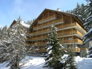 ein großes Holzgebäude im Schnee mit Bäumen in der Unterkunft Appartement Méribel, 2 pièces, 6 personnes - FR-1-180-66 in Méribel