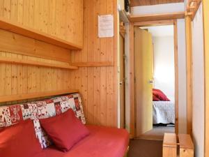 Pokój z czerwoną kanapą i sypialnią w obiekcie Appartement Méribel, 2 pièces, 5 personnes - FR-1-180-92 w Méribel