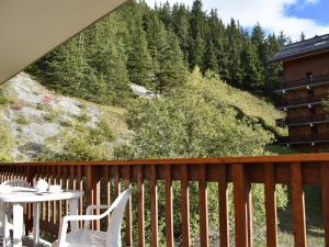 a balcony with a table and chairs and a mountain at Appartement Méribel, 2 pièces, 5 personnes - FR-1-180-92 in Méribel