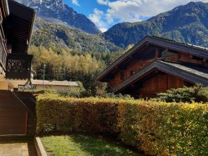 żywopłot przed budynkiem z górami w tle w obiekcie Appartement charme avec terrasse, vue Mont Blanc, parking, 3/4 pers - FR-1-517-65 w Chamonix-Mont-Blanc