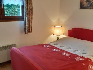 sypialnia z łóżkiem z czerwono-białym kocem w obiekcie Appartement charme avec terrasse, vue Mont Blanc, parking, 3/4 pers - FR-1-517-65 w Chamonix-Mont-Blanc