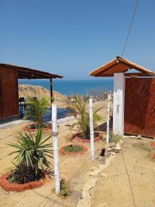 a house with white poles in front of the ocean at Cabana con Vista al Mar in La Bocana