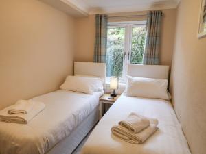 two twin beds in a room with a window at Ambleside Haven in Ambleside