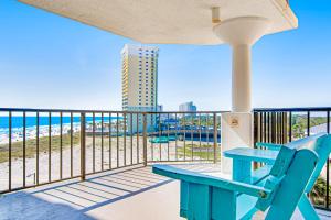 a balcony with a blue bench and a view of the beach at Top of the Gulf 702 Teal Waters in Panama City Beach