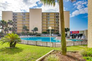 a pool in front of a hotel with palm trees at Top of the Gulf 702 Teal Waters in Panama City Beach