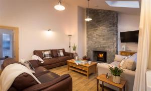 uma sala de estar com um sofá e uma lareira em Lanterns At Grasmere em Grasmere