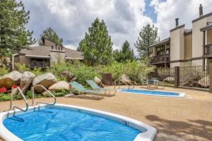 a pool with two chairs and a house at Sherwin Villas 12 B in Mammoth Lakes