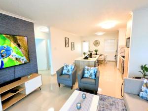 a living room with a large flat screen tv at Pristine King Size Bed Apartment In Secure Complex in Durban