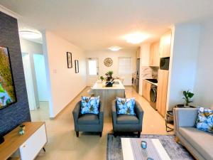 uma sala de estar com duas cadeiras e uma mesa em Pristine King Size Bed Apartment In Secure Complex em Durban