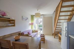 a kitchen and living room with a table and a staircase at Le Nid in Aureilhan