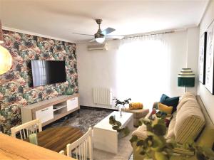 ein Wohnzimmer mit einem Sofa und einem TV an der Wand in der Unterkunft Piso-Loft COS Centro Jaén 2 in Jaén
