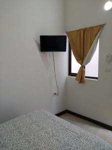 a bedroom with a bed and a flat screen tv at Casa Rosanna in Campeche