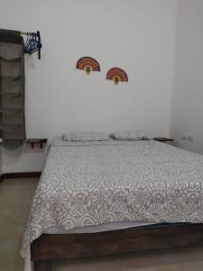 a bedroom with a bed with a comforter at Casa Rosanna in Campeche