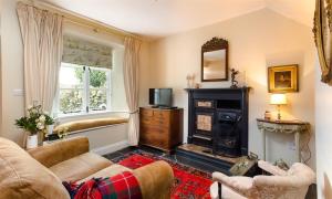 a living room with a couch and a fireplace at The Blithe Hare in Windermere