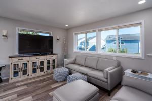 a living room with a couch and a flat screen tv at Ocean Aire in Bandon