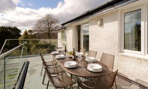 a wooden table and chairs on a balcony at Hillhead in Ambleside