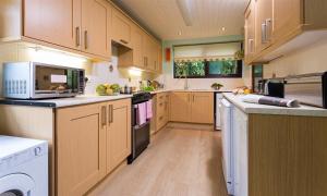 a large kitchen with wooden cabinets and appliances at Fairhaven in Bowness-on-Windermere
