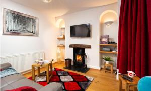 uma sala de estar com um sofá e uma lareira em Oak Cottage em Bowness-on-Windermere