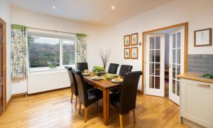 a dining room with a table and chairs and a window at Fairfield Cottage in Grasmere