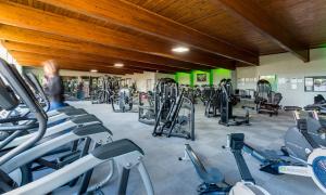 a gym with a lot of treadmills and machines at Fairfield Cottage in Grasmere