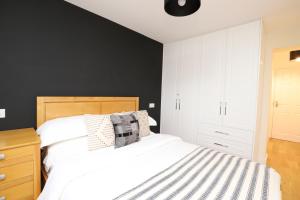 a bedroom with a white bed and a black wall at Luxurious double bedroom, ensuite with free Wifi. in Oxford