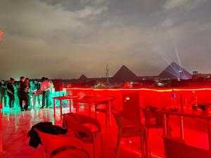 a group of people standing in a room with red lights at Khufu Pyramids Hotel in Cairo