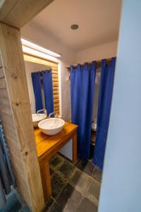 a bathroom with two sinks and blue shower curtains at Hacienda Cocuyo in Monte Rojo