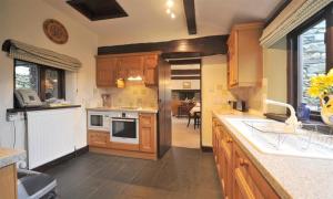 una cucina con mobili in legno e un forno a piano cottura di Butt Hill Cottage a Troutbeck