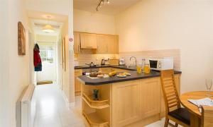 a kitchen with a counter and a table and a microwave at Riverside Cottages No 2 in Ambleside