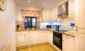 a kitchen with white cabinets and a stove top oven at River Falls View in Ambleside